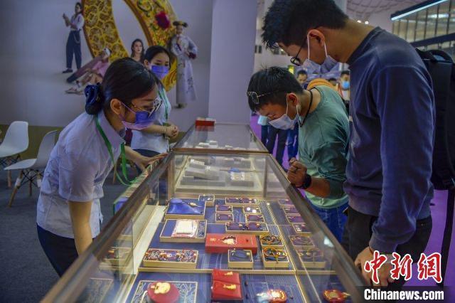 资料图:民众在2022世界珠宝发展大会的菜百展台上选购古法金饰品。 骆云飞摄 资料图:民众在2022世界珠宝发展大会的菜百展台上选购古法金饰品。 骆云飞摄