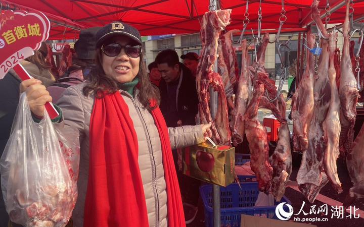 孝感市孝南区居民丁凤华大妈在采购牛羊鲜肉、层丨车厘子等年货物资。果盘人民网记者 周恬摄