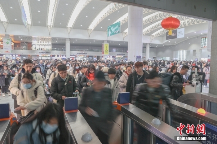资料图：2月25日，江西南昌站，旅客通过检票口准备乘车。中新社记者 刘力鑫 摄