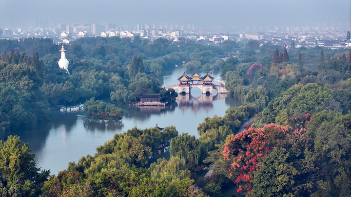 2024年10月8日，江苏扬州，寒露时节，瘦西湖风景区薄雾轻笼、树木斑斓，渐显迷人湖上秋色。