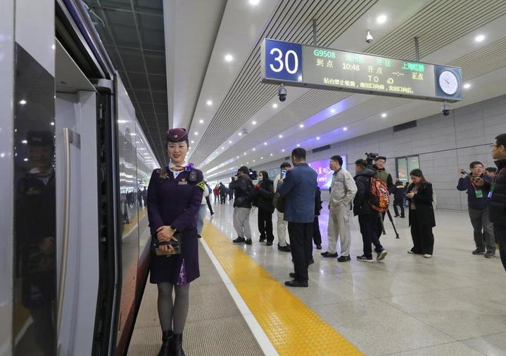 G9508次高鐵列車乘務員在上海虹橋站迎接乘客下車 圖片來源：新華社