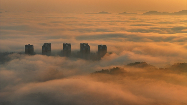 2025年1月10日，湖南省邵阳市洞口县，雪后初晴，太阳升起，晨光中云海波动，村庄、城市犹如海市蜃楼，蔚为壮观。