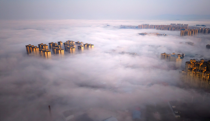 2025年1月10日，湖南省邵阳市洞口县，雪后初晴，太阳升起，晨光中云海波动，村庄、城市犹如海市蜃楼，蔚为壮观。