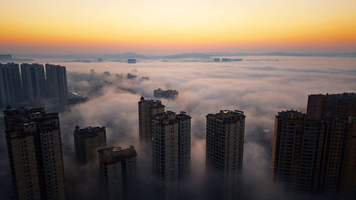 2025年1月10日，湖南省邵阳市洞口县，雪后初晴，太阳升起，晨光中云海波动，村庄、城市犹如海市蜃楼，蔚为壮观。