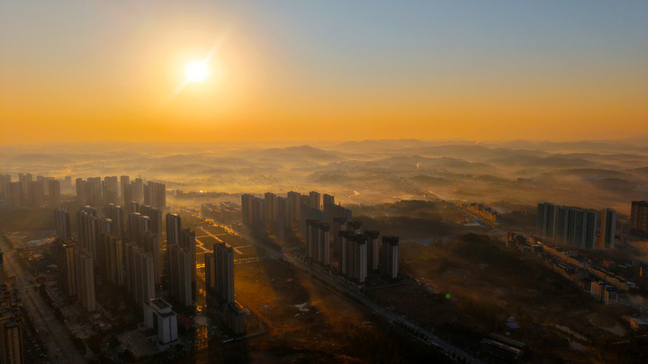 2025年1月10日，湖南省邵阳市洞口县，雪后初晴，太阳升起，晨光中云海波动，村庄、城市犹如海市蜃楼，蔚为壮观。