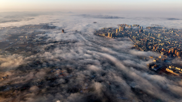 2025年1月10日，湖南省邵阳市洞口县，雪后初晴，太阳升起，晨光中云海波动，村庄、城市犹如海市蜃楼，蔚为壮观。