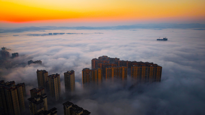 2025年1月10日，湖南省邵阳市洞口县，雪后初晴，太阳升起，晨光中云海波动，村庄、城市犹如海市蜃楼，蔚为壮观。