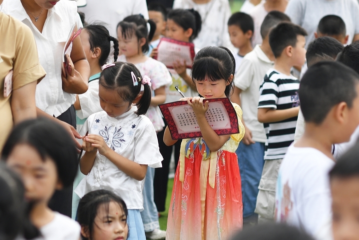 2025年8月30日，小朋友在山东省青岛市城阳区夏庄街道古镇小学开学日活动上书写“人”字。
