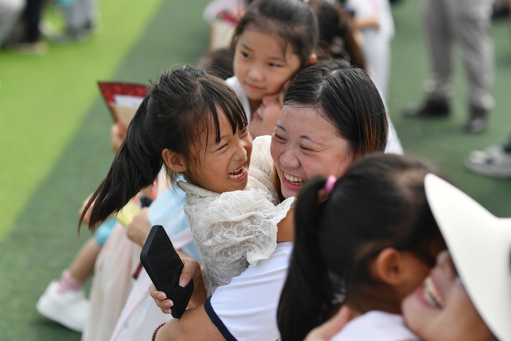 2025年8月30日，小朋友在山东省青岛市城阳区夏庄街道古镇小学开学日活动上拥抱母亲，感谢养育之恩。
