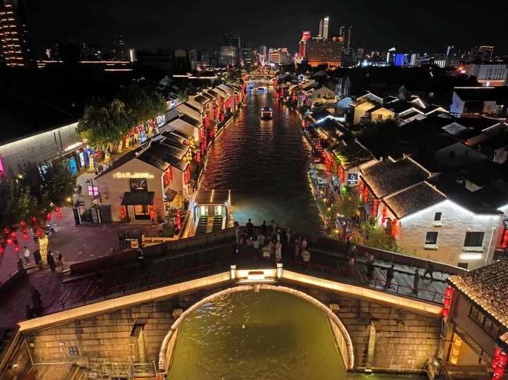 2025年9月23日，京杭运河江苏无锡段，夜晚的古运河景区游船穿梭、游人如织，丰富的历史遗存引来众多游客观景“打卡”。

