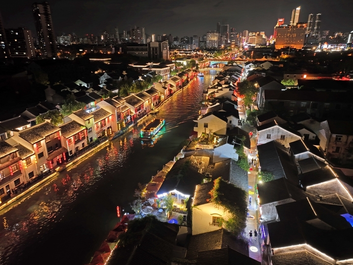 2025年9月23日，京杭运河江苏无锡段，夜晚的古运河景区游船穿梭、游人如织，丰富的历史遗存引来众多游客观景“打卡”。

