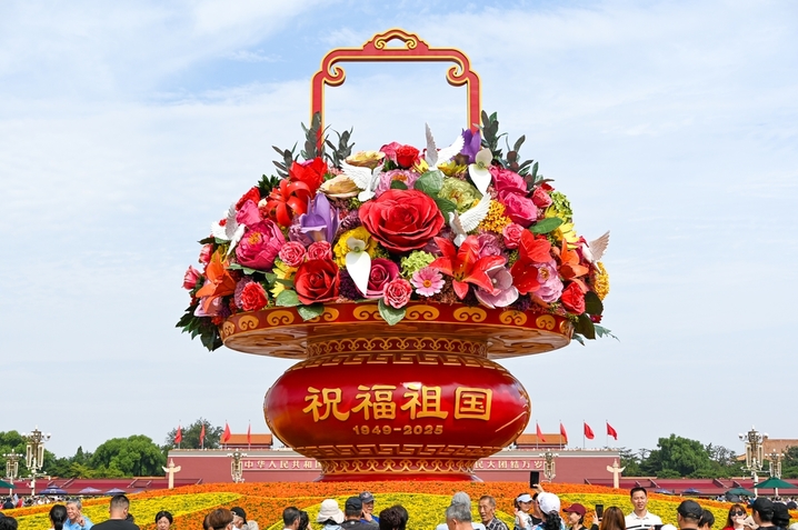 2025年9月26日，北京，天安门广场，游客在庆祝国庆节的花篮前拍照打卡。