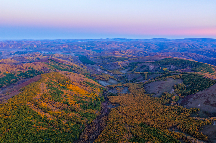 2025年9月26日，内蒙古赤峰黄岗梁秋意正浓，山林被金黄、橙红等色彩晕染，蜿蜒道路穿梭其间，宛如大自然绘就的绝美画卷，美不胜收。
