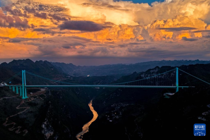 9月28日拍摄的夕阳下的贵州花江峡谷大桥（无人机照片）。
经过三年多建设，新的世界第一高桥——贵州花江峡谷大桥于9月28日正式建成通车。花江峡谷大桥是贵州六枝至安龙高速公路的控制性工程，大桥全长2890米，主跨1420米，是目前世界山区峡谷第一大跨度钢桁梁悬索桥；其桥面距水面垂直高度625米，超越北盘江第一桥成为新的世界第一高桥，被誉为“横竖都是第一”。在不同时段的光线下，世界第一高桥呈现出不同的美景。新华社记者 杨文斌 摄