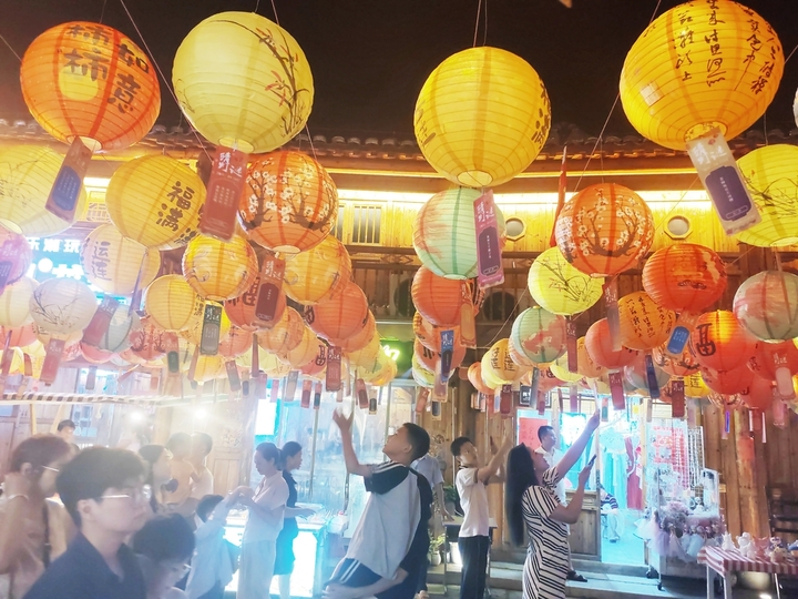 2025年10月2日晚，江西省吉安市永丰县恩江古城下西坊历史文化街区，市民在迎中秋灯谜竞猜活动上猜灯谜。2025年10月2日，江西省吉安市永丰县在恩江古城举行迎中秋灯谜竞猜活动，吸引众多市民和游客参与，感受传统民俗魅力，喜迎中秋佳节。
