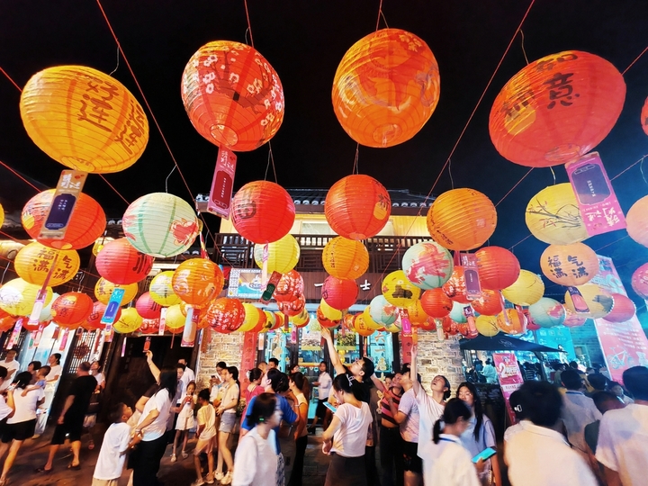 2025年10月2日晚，江西省吉安市永丰县恩江古城下西坊历史文化街区，市民在迎中秋灯谜竞猜活动上猜灯谜。2025年10月2日，江西省吉安市永丰县在恩江古城举行迎中秋灯谜竞猜活动，吸引众多市民和游客参与，感受传统民俗魅力，喜迎中秋佳节。
