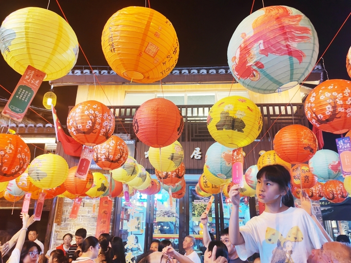 2025年10月2日晚，江西省吉安市永丰县恩江古城下西坊历史文化街区，市民在迎中秋灯谜竞猜活动上猜灯谜。2025年10月2日，江西省吉安市永丰县在恩江古城举行迎中秋灯谜竞猜活动，吸引众多市民和游客参与，感受传统民俗魅力，喜迎中秋佳节。来源：刘浩军/IC photo
