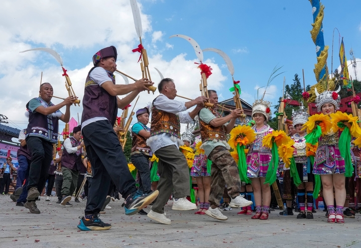 2025年10月2日，在广西柳州市融水苗族自治县安太乡洞安侗寨，村民围着城里来的“同年”吹奏芦笙欢迎曲。


