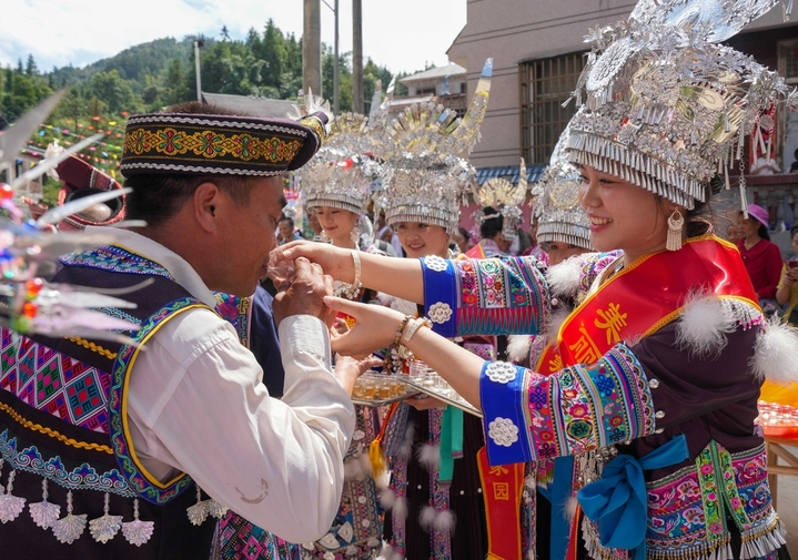 2025年10月2日，在广西柳州市融水苗族自治县安太乡洞安侗寨，侗家姑娘向城里来的“同年”敬进寨酒。


