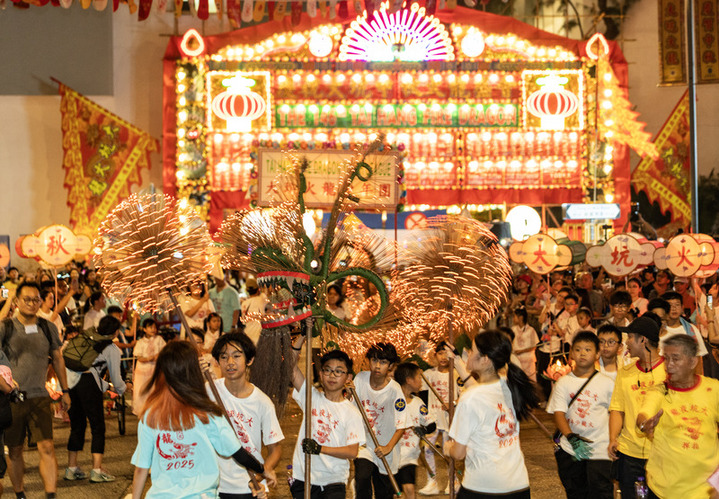 2025年10月5日晚，香港“大坑舞火龙”再度于铜锣湾大坑的大街小巷上演。“大坑舞火龙”2011年被列入国家级非物质文化遗产代表性项目名录，是香港庆祝中秋节的重要节庆盛事活动。图为少年儿童用发光二极管（LED）制成的“小火龙”进行表演。