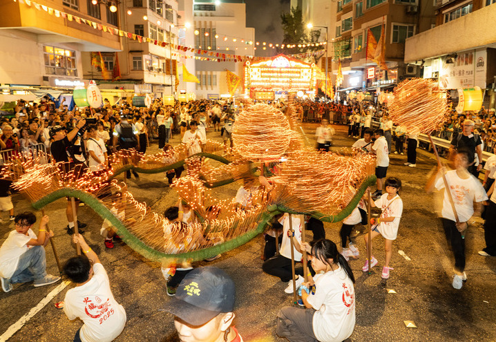 2025年10月5日晚，香港“大坑舞火龙”再度于铜锣湾大坑的大街小巷上演。“大坑舞火龙”2011年被列入国家级非物质文化遗产代表性项目名录，是香港庆祝中秋节的重要节庆盛事活动。图为少年儿童用发光二极管（LED）制成的“小火龙”进行“起结龙团”（又称“打龙饼”）表演。  