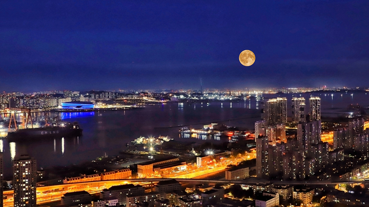 2025年10月6日，辽宁大连，中秋节一轮圆月从大连梭鱼湾东方海岸线升起。

