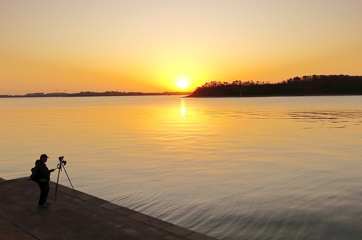 2025年12月8日，山东青岛，日出时分，素有“海上西湖”美誉的唐岛湾波光粼粼，水天一色，如画美景令人心旷神怡。