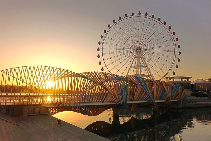 2025年12月8日，山东青岛，日出时分，素有“海上西湖”美誉的唐岛湾波光粼粼，水天一色，如画美景令人心旷神怡。IC photo