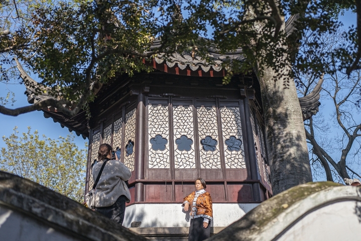 2025年12月9日，江苏苏州拙政园，游客和宜两亭合影。
