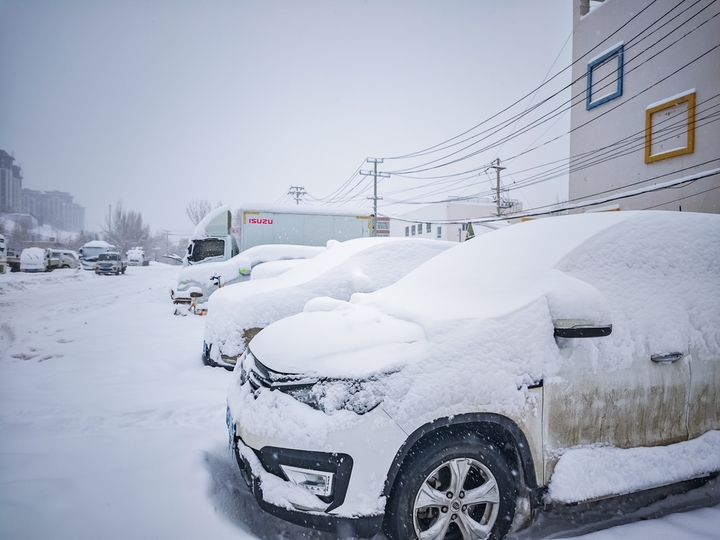2025年12月10日，新疆阿勒泰，新疆阿勒泰降大雪，铲雪车和工人紧急清扫道路，保障市民出行安全。