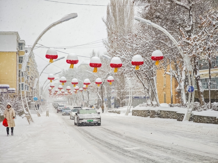 2025年12月10日，新疆阿勒泰，新疆阿勒泰降大雪，铲雪车和工人紧急清扫道路，保障市民出行安全。