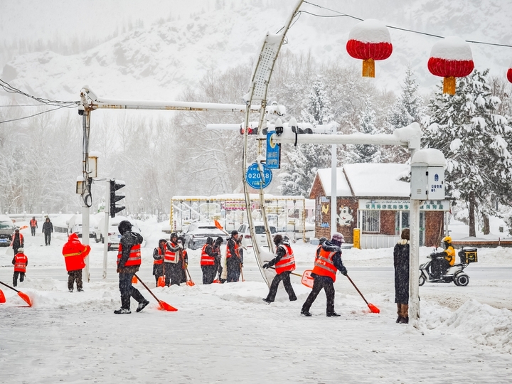 2025年12月10日，新疆阿勒泰，新疆阿勒泰降大雪，铲雪车和工人紧急清扫道路，保障市民出行安全。IC photo