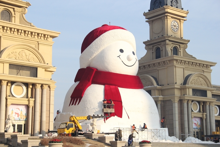 2025年12月15日，黑龙江省哈尔滨市，道里区群力江畔音乐广场上的网红大雪人制作已基本完成，吸引了许多游客前来打卡拍照。 今年的网红大雪人身高19米、长14米、宽11米，比往年高了1米，用雪量增加了1200立方米，总用雪量超3000立方米，达到历年之最。