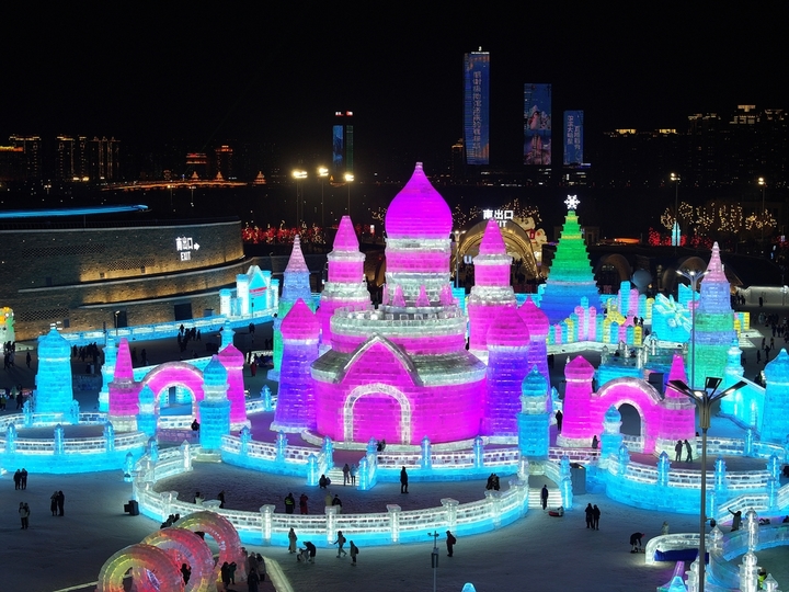 2025年12月20日，黑龙江省哈尔滨市，第二十七届哈尔滨冰雪大世界园区内，梦幻城堡景观区成为冬日焦点。这座最高处达24米的冰建奇观，以13200立方米晶莹剔透的冰堆砌而成，在寒风中闪耀着童话般的光泽。特别设计的圆形打卡点宛如天然画框，吸引众多女游客驻足留影。当人们端坐其间，仿佛置身于冰雪编织的梦境，每一个角落都散发着童话书里才有的浪漫气息，共同构筑起一个晶莹剔透的冰雪乌托邦。IC photo