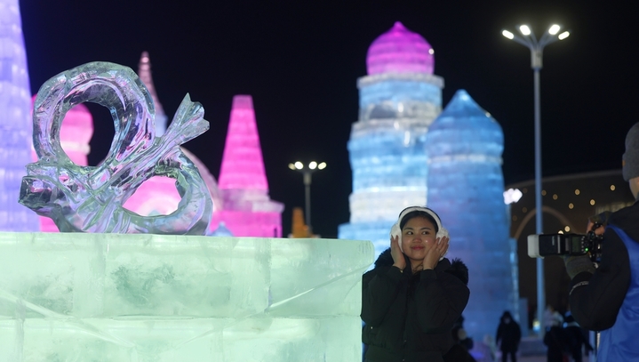 2025年12月20日，黑龙江省哈尔滨市，第二十七届哈尔滨冰雪大世界园区内，梦幻城堡景观区成为冬日焦点。这座最高处达24米的冰建奇观，以13200立方米晶莹剔透的冰堆砌而成，在寒风中闪耀着童话般的光泽。特别设计的圆形打卡点宛如天然画框，吸引众多女游客驻足留影。当人们端坐其间，仿佛置身于冰雪编织的梦境，每一个角落都散发着童话书里才有的浪漫气息，共同构筑起一个晶莹剔透的冰雪乌托邦。