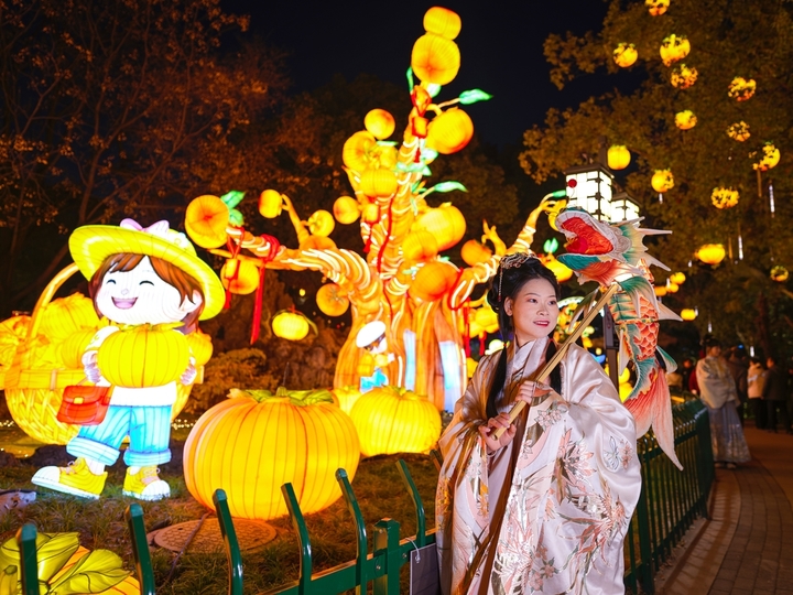 2025年12月27日，游客在南京白鹭洲公园观赏花灯。元旦将至，南京白鹭洲公园精品灯彩艺术展区花灯璀璨，吸引许多市民和游客前来赏灯游玩，喜迎新年。
