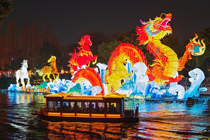 2025年12月27日，游客在南京白鹭洲公园观赏花灯。元旦将至，南京白鹭洲公园精品灯彩艺术展区花灯璀璨，吸引许多市民和游客前来赏灯游玩，喜迎新年。
