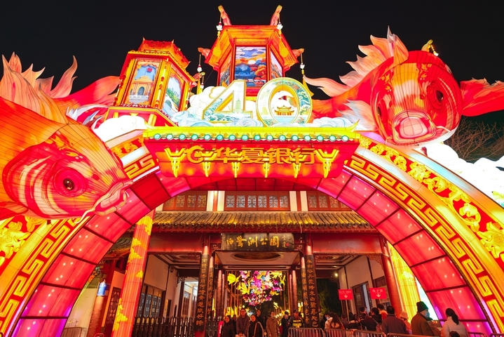 2025年12月27日，游客在南京白鹭洲公园观赏花灯。元旦将至，南京白鹭洲公园精品灯彩艺术展区花灯璀璨，吸引许多市民和游客前来赏灯游玩，喜迎新年。
