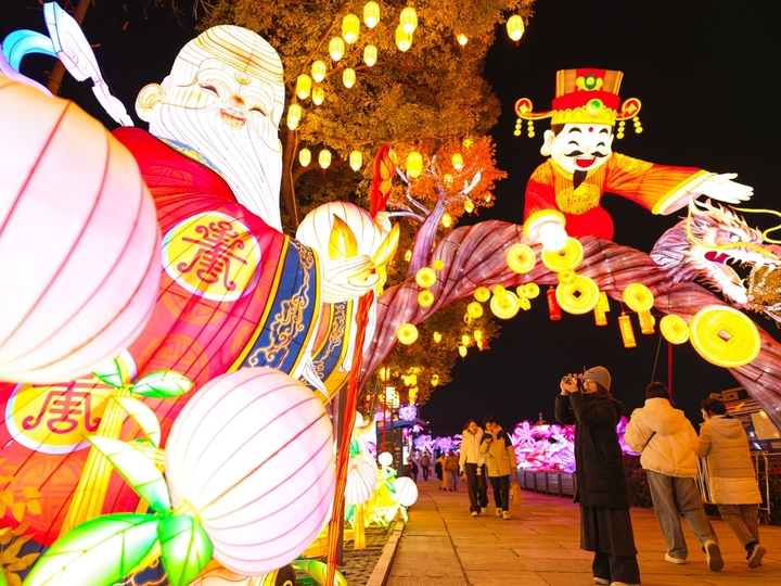 2025年12月27日，游客在南京白鹭洲公园观赏花灯。元旦将至，南京白鹭洲公园精品灯彩艺术展区花灯璀璨，吸引许多市民和游客前来赏灯游玩，喜迎新年。
