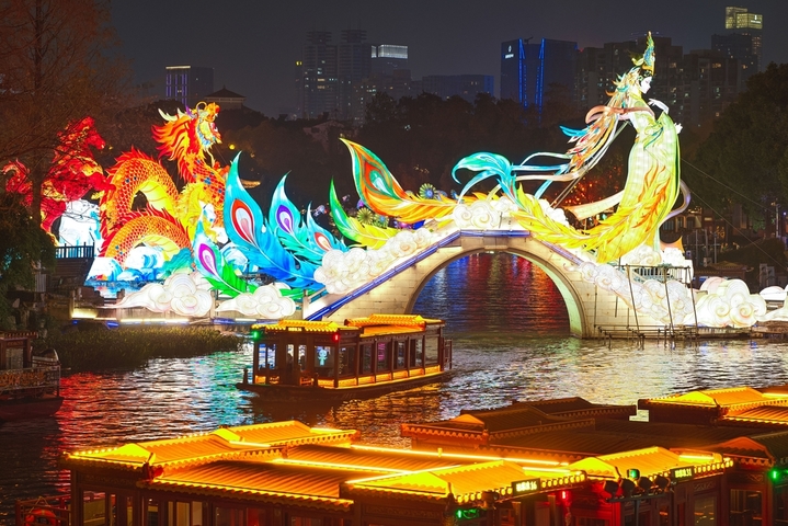 2025年12月27日，游客在南京白鹭洲公园观赏花灯。元旦将至，南京白鹭洲公园精品灯彩艺术展区花灯璀璨，吸引许多市民和游客前来赏灯游玩，喜迎新年。来源：IC photo

