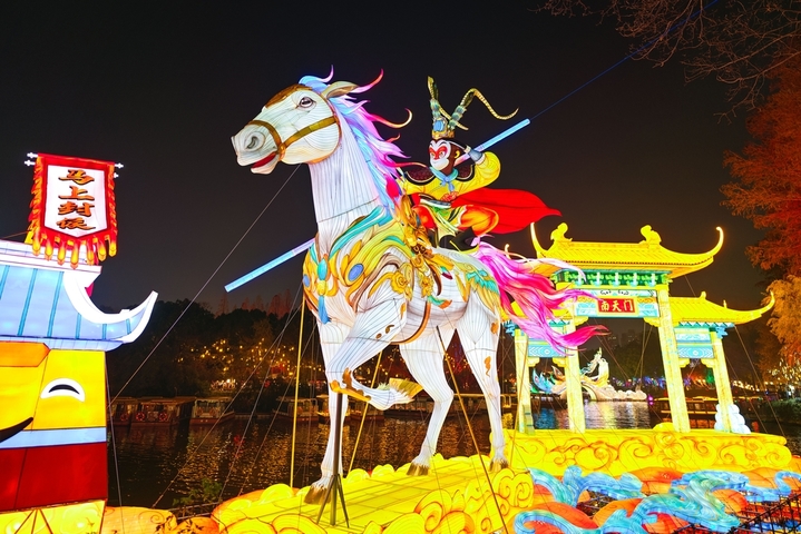 2025年12月27日，游客在南京白鹭洲公园观赏花灯。元旦将至，南京白鹭洲公园精品灯彩艺术展区花灯璀璨，吸引许多市民和游客前来赏灯游玩，喜迎新年。
