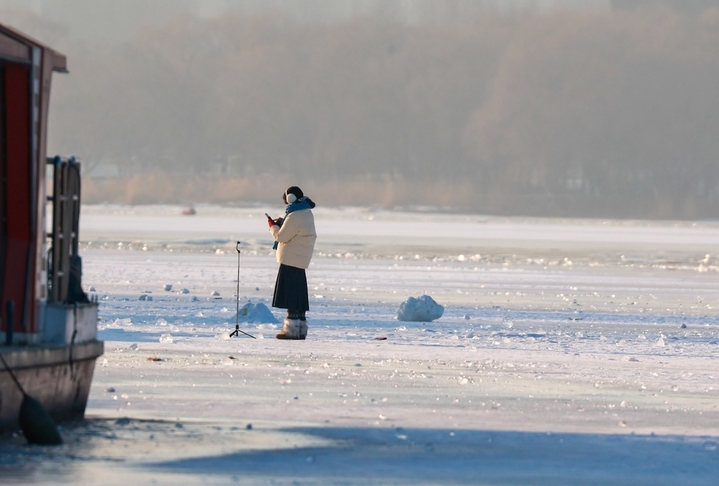 2026年1月4日，沈阳市民在浑河沈阳段的冰河上游玩、拍照，享受冬日时光。 