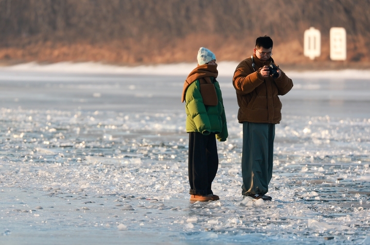 2026年1月4日，沈阳市民在浑河沈阳段的冰河上游玩、拍照，享受冬日时光。 