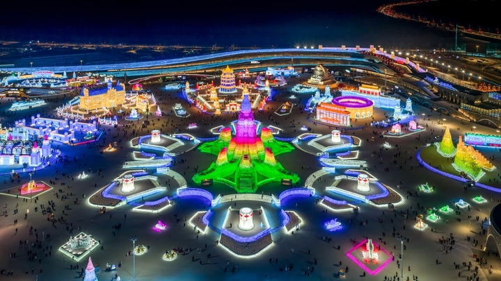 2026年1月5日，正值小寒节气，黑龙江省哈尔滨市，哈尔滨冰雪大世界冰雪节启幕，夜幕下，烟花腾空绽放，流光溢彩映亮冰雕玉砌的世界；无人机编队凌空起舞，变幻出骏马、雪花等灵动造型，各式冰雕晶莹剔透，5万游客驻足观赏拍照。
