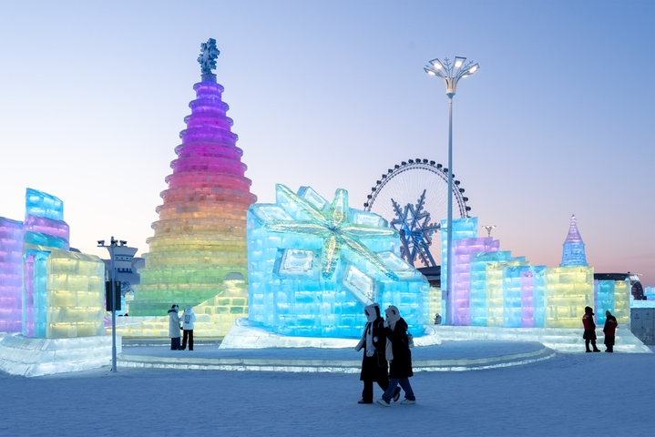 2026年1月5日，正值小寒节气，黑龙江省哈尔滨市，哈尔滨冰雪大世界冰雪节启幕，夜幕下，烟花腾空绽放，流光溢彩映亮冰雕玉砌的世界；无人机编队凌空起舞，变幻出骏马、雪花等灵动造型，各式冰雕晶莹剔透，5万游客驻足观赏拍照。
