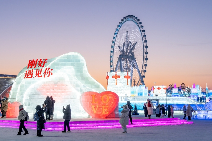 2026年1月5日，正值小寒节气，黑龙江省哈尔滨市，哈尔滨冰雪大世界冰雪节启幕，夜幕下，烟花腾空绽放，流光溢彩映亮冰雕玉砌的世界；无人机编队凌空起舞，变幻出骏马、雪花等灵动造型，各式冰雕晶莹剔透，5万游客驻足观赏拍照。
池世永/IC photo