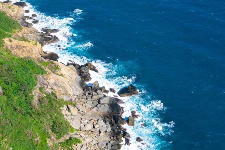 2025年12月17日，海南省陵水黎族自治县，航拍俯瞰海南陵水分界洲岛风景，礁石、浪花、悬崖木屋，海岛风景秀美。分界洲岛是国家5A级旅游景区。大疆御4PRO无人机高清航拍。
