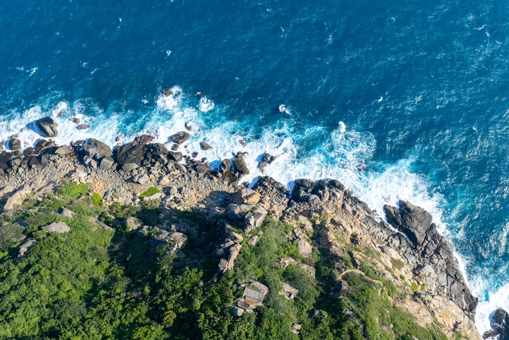 2025年12月17日，海南省陵水黎族自治县，航拍俯瞰海南陵水分界洲岛风景，礁石、浪花、悬崖木屋，海岛风景秀美。分界洲岛是国家5A级旅游景区。大疆御4PRO无人机高清航拍。
