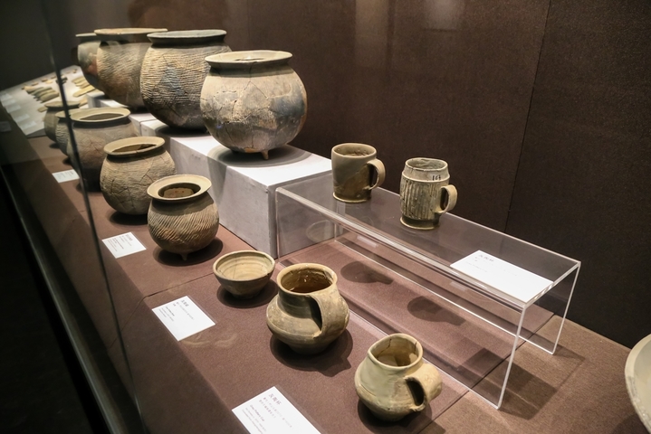 其中一件为条纹灰陶杯，杯为直口，圆唇，深腹，直壁，杯下部略收束，圆足。杯腹部有一条带形鋬，腹部饰竖条纹，简略大方。这件文物是在郑州马庄遗址出土的，马庄遗址是河南龙山文化中期偏晚的遗存，一些主要文物的嬗变过程，有着明显的连续性和阶段性。