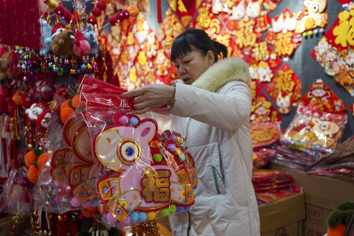 1月14日，河南郑州，随着春节脚步临近，以农历生肖“马”为主题的消费市场呈现出火热态势。图为消费者在选购“马”元素年画。